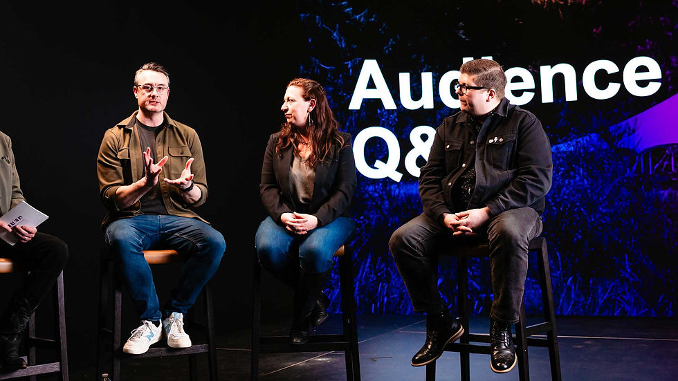 Three panelist presenters engaging in conversation on a stage